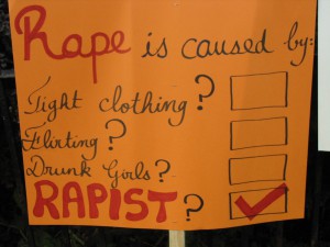 Sign reading "Rape is caused by: Tight clothing? Flirting? Drunk girls? RAPIST?" with a big check beside rapist.