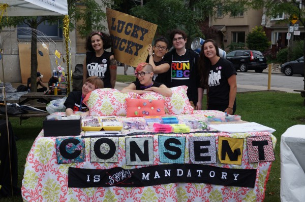 Image of 6 staff people of Community Action Centre (CAC) with their display like a giant decorated bed with message of consent is mandatory in front. Photo: Aloke AnandImage of 6 staff people of Community Action Centre (CAC) with their display like a giant decorated bed with message of consent is mandatory in front