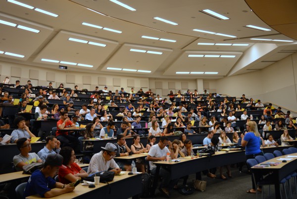Image of International Students sitting on benches in a huge auditorium at Orientation at St. James Campus 