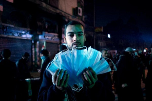 Deceased photojournalists Ali Mustafa holds up masks to protect against teargas in Cairo near Tahrir Square