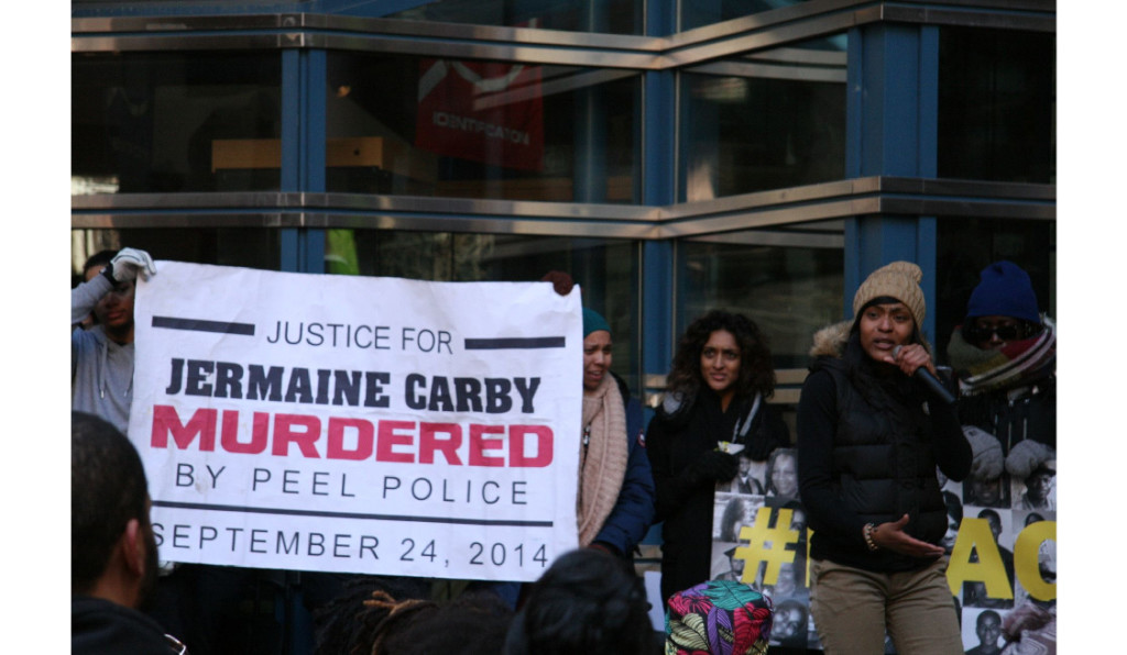 Photo of a banner reading Justice for Jermaine Carby Mudered by Peel Police September 24, 2014