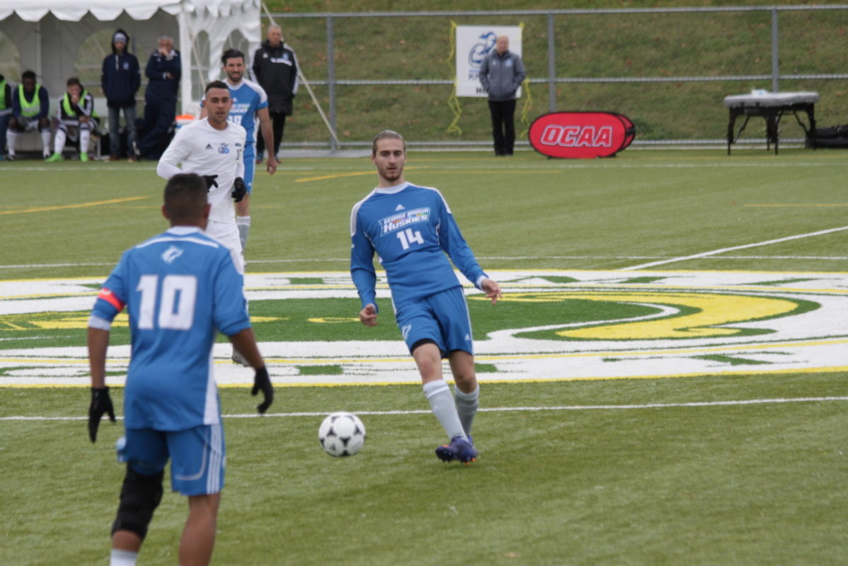Justin Soscia (14) controls the ball as Jesse Oliver looks on against Niagara. Photo: OCAA