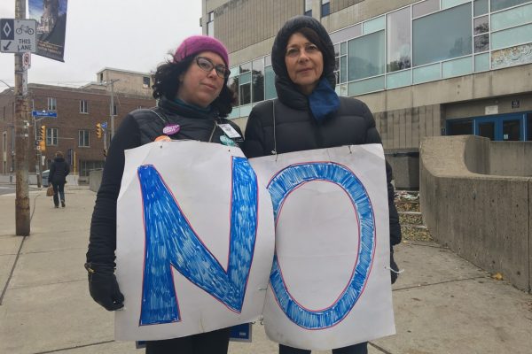 Two picketers at George Brown College's Casa Loma campus wear signs spelling "no" on the morning that striking college faculty rejected an offer fro the colleges by 86 per cent. Photo: Lidianny Botto / The Dialog