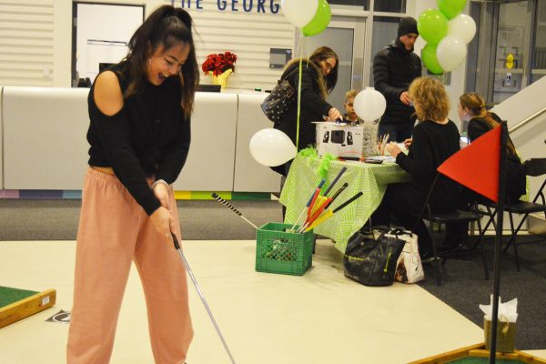 Students bring mini putt to The George Evelin Cheung, left, celebrates her win at Turn Down for Putt. Photo: Nico deVeber / The Dialog